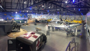 Inside the Fagen Fighters World War Two Museum. A room with airplanes and vehicles on display.