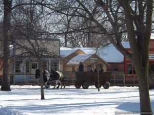 Horse and buggies strolling through Historic Chippewa Village on a winter day.