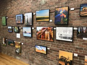 Brick wall covered with photos of rural landscapes.