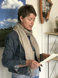 A lady reading from a piece of paper. 