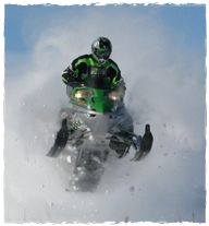 A person riding a snowmobile getting air. 